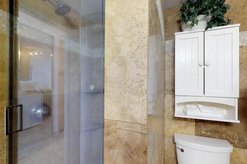 a bathroom with a toilet and a white cabinet at Maui Kai 507 & 508 in Honokowai