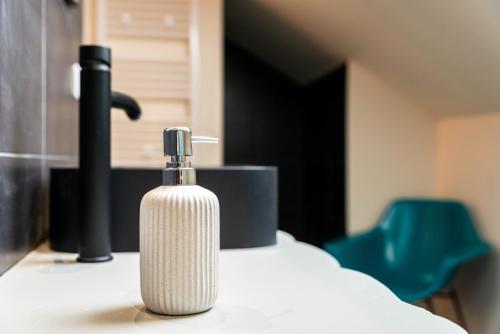 una bottiglia di sapone su un bancone accanto a un lavandino di Ker Iliz a Bédée
