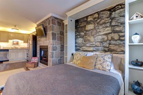 Un dormitorio con una pared de piedra y una cama en Little River Loft & Riverfront Gem, en Townsend