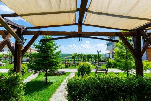 a wooden pavilion with a view of a park at Seven Generations Winery Hotel in Mechka