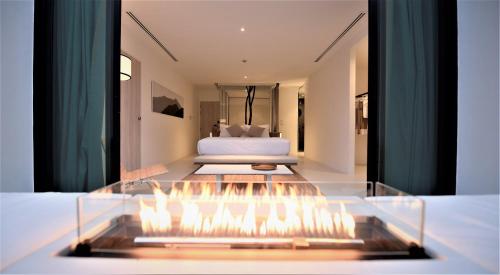 a bedroom with a bed and a fireplace in a room at K Maison Lanna Boutique Hotel-SHA Plus Certified in Chiang Mai