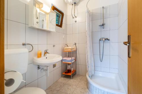 La salle de bains est pourvue de toilettes, d'un lavabo et d'une douche. dans l'établissement Sea view suite Mateo, à Preko