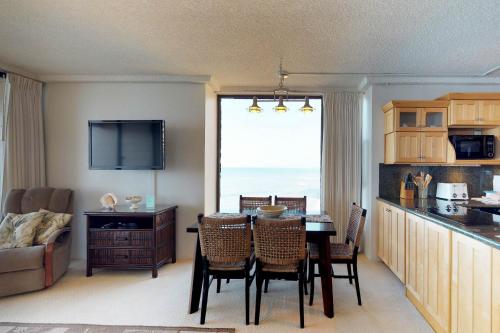 a kitchen and living room with a table and chairs at Maui Kai 507 & 508 in Honokowai