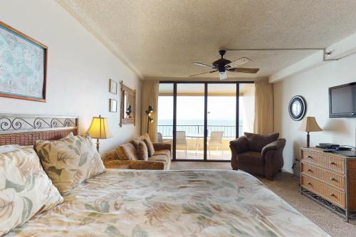 a bedroom with a bed and a couch and a television at Maui Kai 507 & 508 in Honokowai