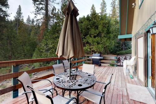a patio with a table and an umbrella on a deck at The Limit in Dora Belle