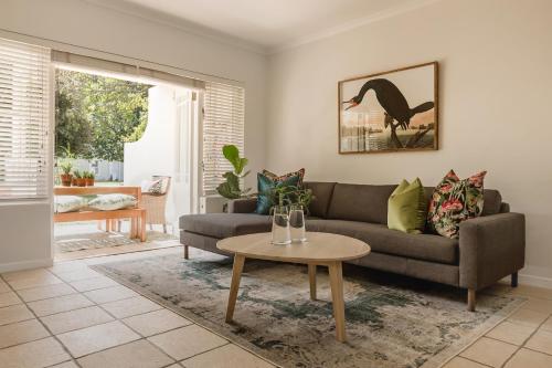 a living room with a couch and a table at Nguni River Apartment in Plettenberg Bay