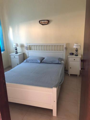 een slaapkamer met een groot wit bed en 2 nachtkastjes bij Vivenda da bela vista in Costa da Caparica