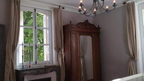 Cette chambre comprend un miroir et un lustre. dans l'établissement Manoir la Rumillette, à Saint-Michel-sur-Loire
