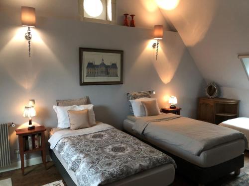 - une chambre avec 2 lits et 2 lampes murales dans l'établissement Manoir la Rumillette, à Saint-Michel-sur-Loire