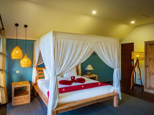 a bedroom with a large bed with a canopy at Villa Cantik in Lovina