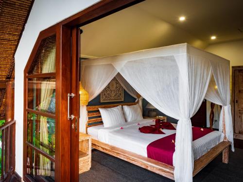 a bedroom with a bed with a canopy at Villa Cantik in Lovina
