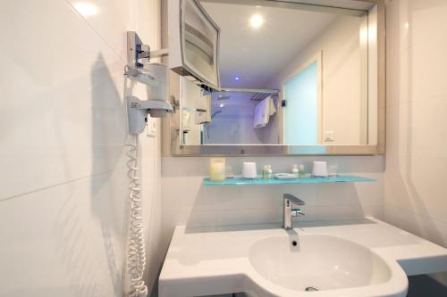 a white bathroom with a sink and a mirror at Piccolo Grand Hotel in Pizzo