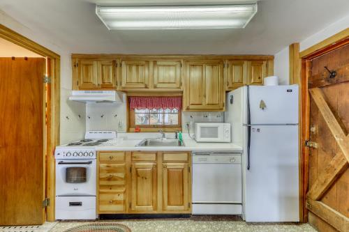 a kitchen with white appliances and wooden cabinets at Sagevick Cabin in Chestertown