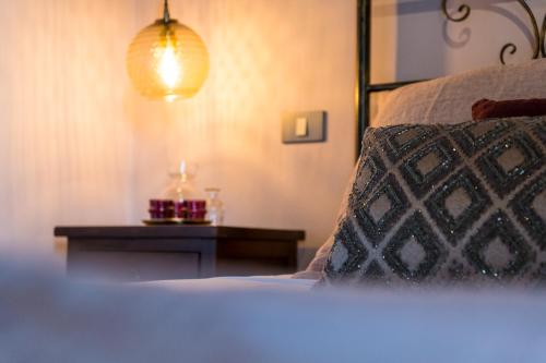a bedroom with a bed with a night stand and a lamp at Borgo Castello Panicaglia in Nocera Umbra
