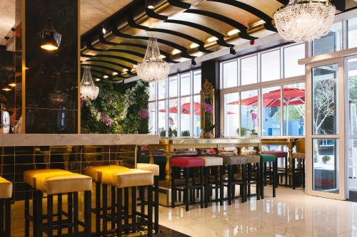 a restaurant with a bar with yellow and red stools at Signature Lux Hotel by ONOMO, Foreshore in Cape Town