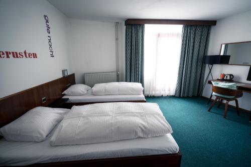 a hotel room with two beds and a desk at Hotel Centraal in Someren