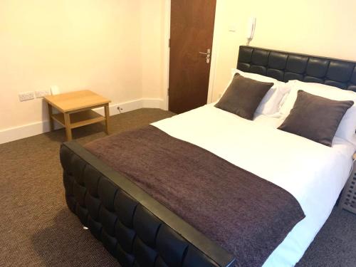 - une chambre avec un grand lit et une table dans l'établissement Serviced Accommodations, à Luton