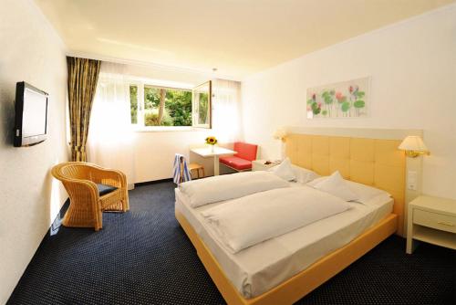 ラーナにあるKröllnerhofのベッド、テーブル、椅子が備わるホテルルームです。