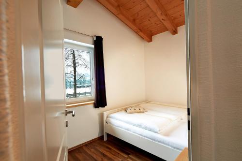 ein kleines Schlafzimmer mit einem Bett und einem Fenster in der Unterkunft Kitz Mountain Living in Aurach bei Kitzbuhel