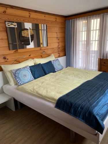 a bedroom with a large bed with a wooden wall at Mazot Zermatt in Zermatt