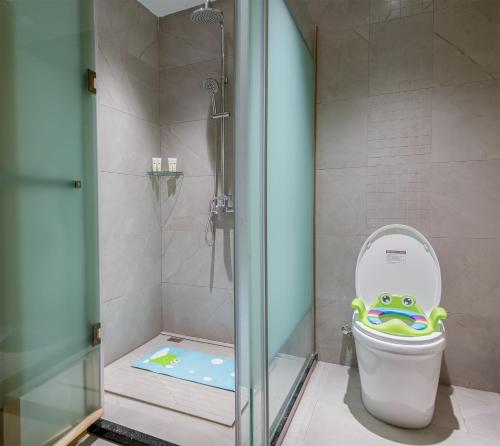 uma casa de banho com um chuveiro e um WC com um brinquedo em Yunxianju Tea Culture Theme Hotel em Kunming