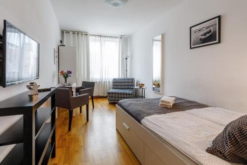 1 dormitorio con cama, escritorio y sofá cama en Apartament Przytulny Centrum 150m od dworca głównego PKP, en Gdansk