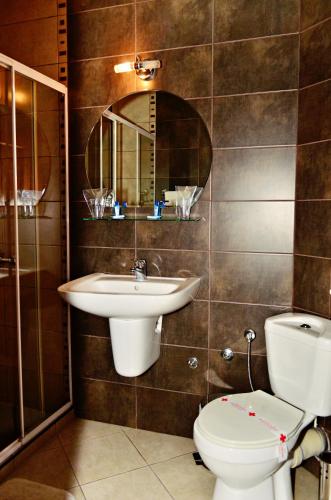 a bathroom with a sink and a toilet and a mirror at Family Hotel Maraya in Arbanasi