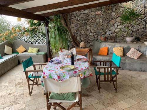 une table et des chaises assises sur une terrasse dans l'établissement Villa Pina, à Praiano