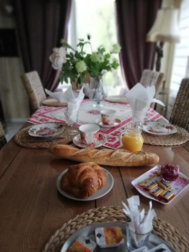 - une table en bois avec des aliments pour le petit-déjeuner dans l'établissement Chambres d'hôtes Sandrine Louis, à Phalsbourg