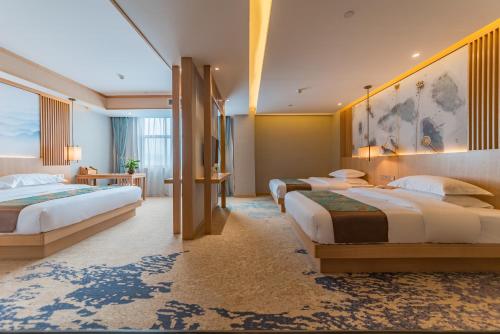 a hotel room with three beds in a room at Yunxianju Tea Culture Theme Hotel in Kunming