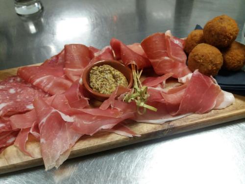 a plate of meat and meatballs on a cutting board at Hotel Centraal in Someren
