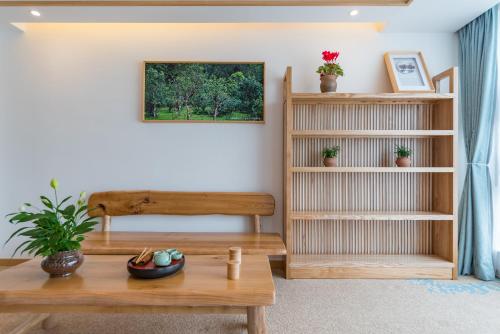 a living room with a table and a bench at Yunxianju Tea Culture Theme Hotel in Kunming