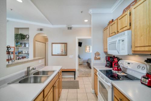 a kitchen with a sink and a stove at Pristine Top Floor Condo With Access To Clubhouse & Pools in Phoenix