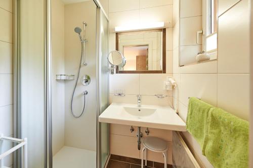 uma casa de banho com um lavatório e um chuveiro em Haus Alpenheim em Flachau