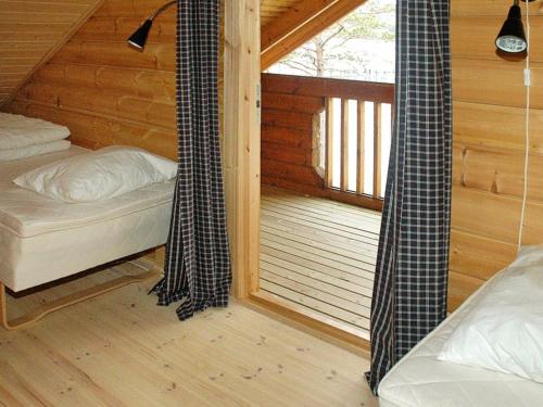 a room with two beds and a window in a cabin at 5 person holiday home in VÅGLAND in Bårdset