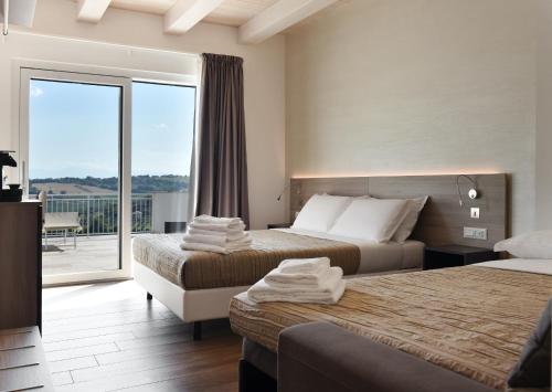 a hotel room with two beds and a balcony at Casablanca Hotel in Civitanova Marche