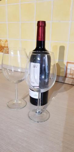 una bottiglia di vino e due bicchieri di vino su un tavolo di Casa Vacanza Rosa a Pozzallo