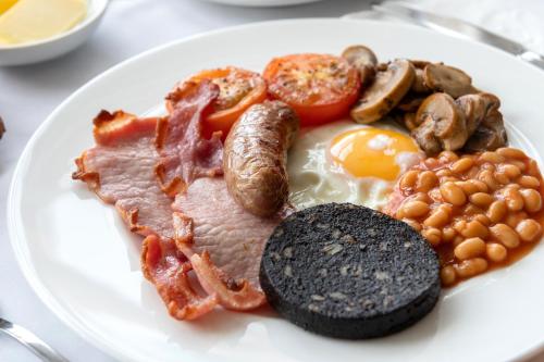 Bodnant Guest House في خلنددنو: طبق من طعام الإفطار مع البيض لحم الخنزير المقدد والفطر