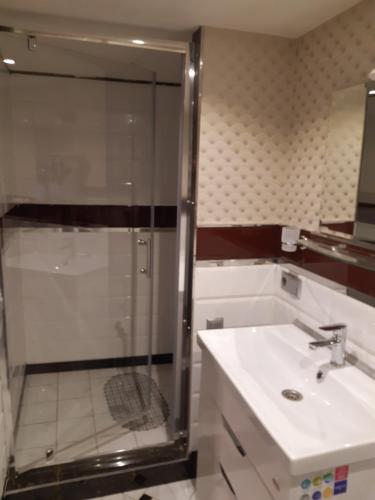 ein Bad mit einer Glasdusche und einem Waschbecken in der Unterkunft Квартира студія подобово 3 in Lwiw