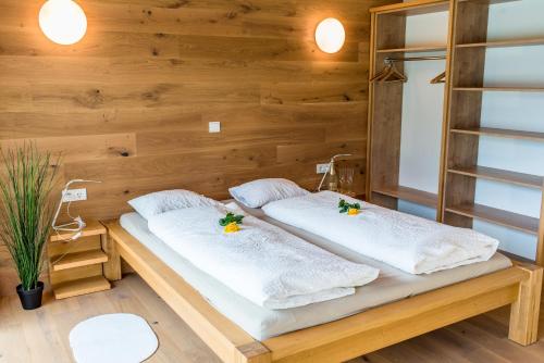 Duas camas num quarto com paredes de madeira em Ferienbungalow Mountain View Wood em Spital am Pyhrn