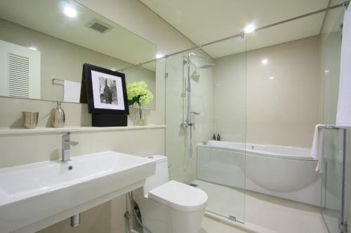 a bathroom with a toilet and a sink and a shower at Ivy Thonglor 55 in Bangkok