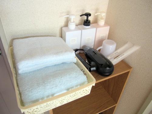 uma prateleira de madeira com toalhas e outros itens nela em Free bike & free WIFI 301 Take it easy em Quioto
