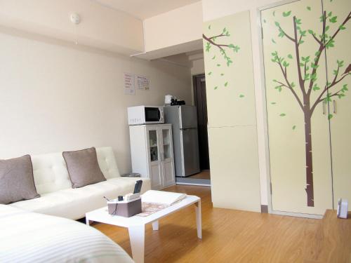 a living room with a couch and a tree on the wall at Free bike & free WIFI 301 Take it easy in Kyoto