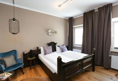 ランツベルク・アム・レヒにあるArthotel ANA Gogglのベッドルーム1室(ベッド1台、青い椅子付)