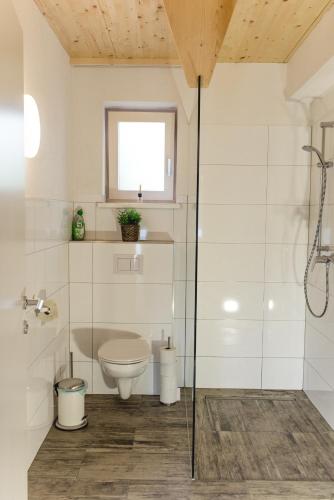 Un baño blanco con inodoro y ducha. en Ferienbungalow Mountain View Wood, en Spital am Pyhrn