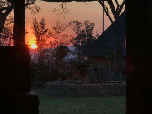a sunset seen through a window of a house at Kwakunje Guest Lodge in Dundee