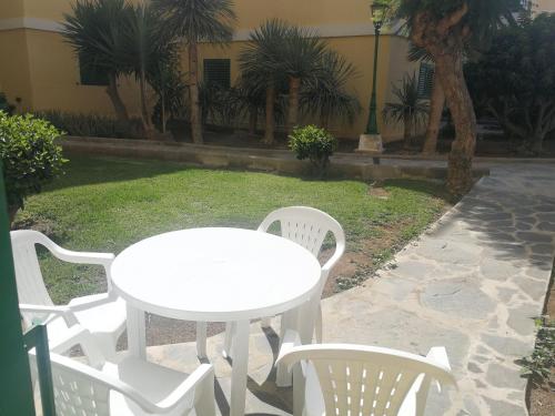 
a white table and chairs in front of a patio at Huella Canaria in Playa del Ingles
