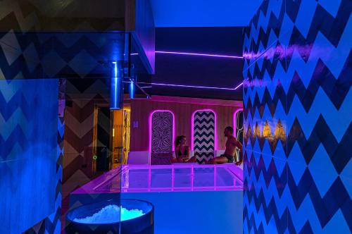 two people sitting in a tub in a room with purple lights at Hotel Le Agavi in Positano