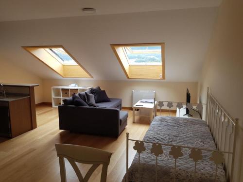 a living room with two skylights and a couch at Curota Vacaciones in A Pobra do Caramiñal