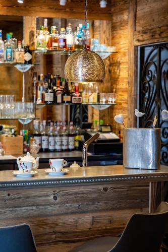a bar with a counter with two cups and a sink at Hôtel SPA du Lac de Madine - Maison DRAPIER in Heudicourt-sous-les-Côtes